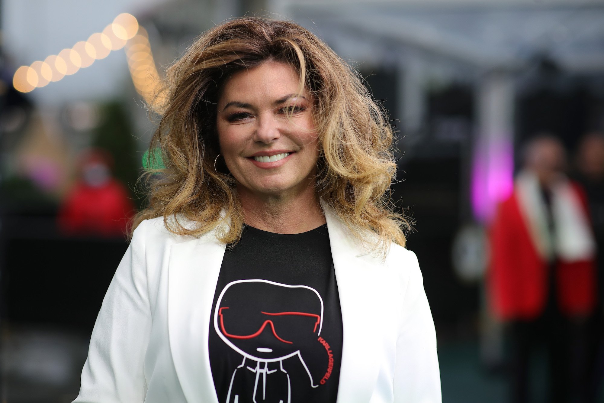 Shania Twain, who was once called 'America's Best Paid Lap Dancer', wearing a white jacket and black T-shirt.