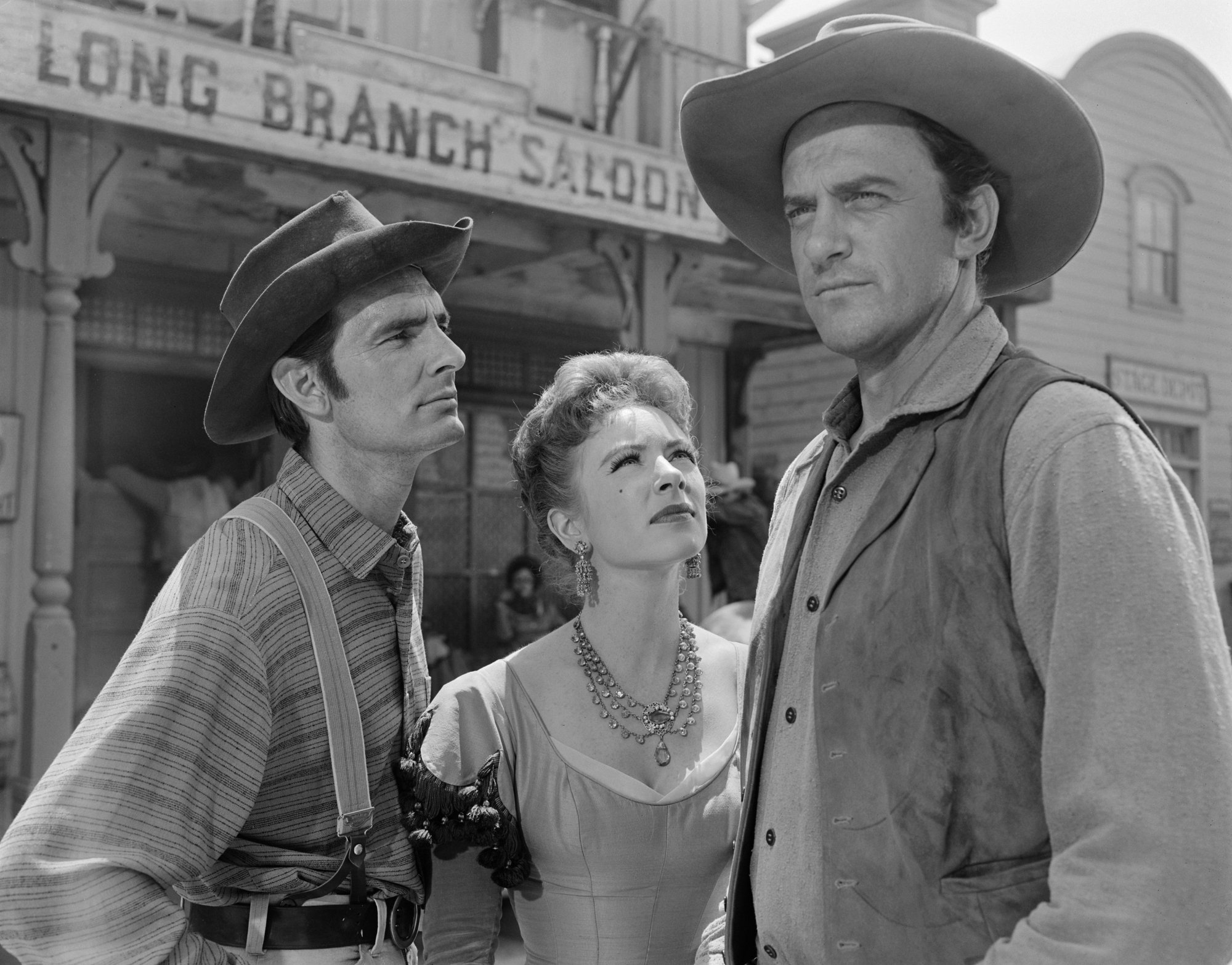 Successful show 'Gunsmoke' Dennis Weaver as Chester Goode, Amanda Blake as Kitty Russell and James Arness as Marshal Matt Dillon. Matt is looking onward, while Kitty and Chester are looking at him. The Long Branch Saloon in the background.