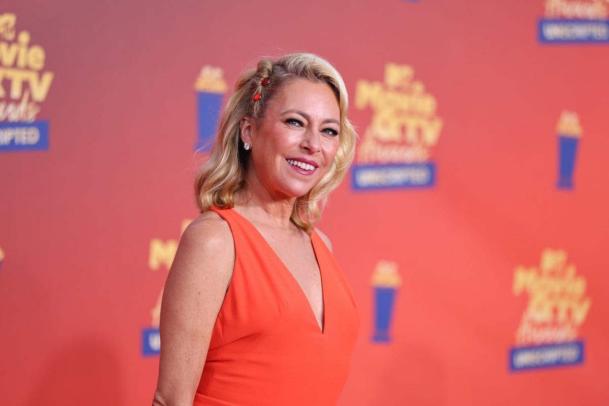 Sutton Stracke smiles at the 2022 MTV Movie & TV Awards while wearing an orange jumpsuit