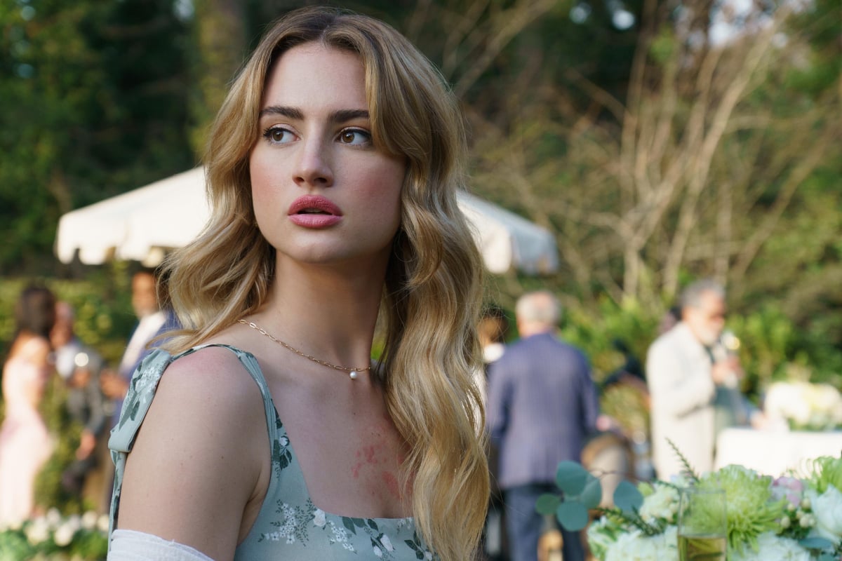 Grace Van Patten as Lucy in Tell Me Lies. Lucy has long blonde hair and wears a floral blue dress.