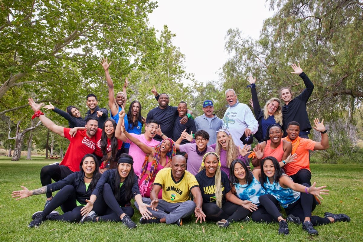 'The Amazing Race' Season 34 cast, including Aubrey Ares & David Hernandez, Quinton Peron & Mattie Lynch, Marcus Craig & Michael Craig, Rex Ryan & Tim Mann, Abby Garrett & Will Freeman, Luis Colon & Michelle Burgos, Rich Kuo & Dom Jones, Derek Xiao & Claire Rehfuss, Glenda Roberts & Lumumba Roberts, Aastha Lal & Nina Duong, Linton Atkinson & Sharik Atkinson, and Emily Bushnell & Molly Sinert, poses for a picture in a park surrounded by trees.