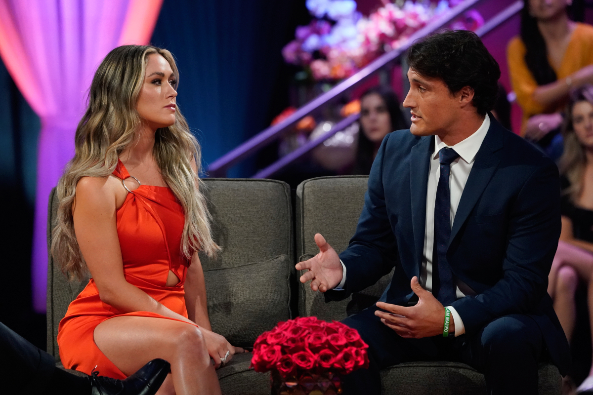 Rachel Recchia and Tino Franco on The Bachelorette Season 19 finale. Tino talks while sitting on the couch next to Rachel, who looks angry. 