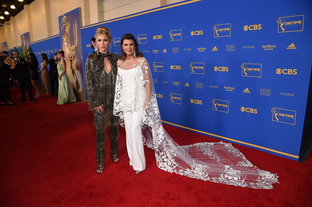 'The Bold and the Beautiful' star Alexes Pelzer in a black sparkly suit, and Kimberlin Brown in a white jumpsuit pose together at the 2022 Daytime Emmys.
