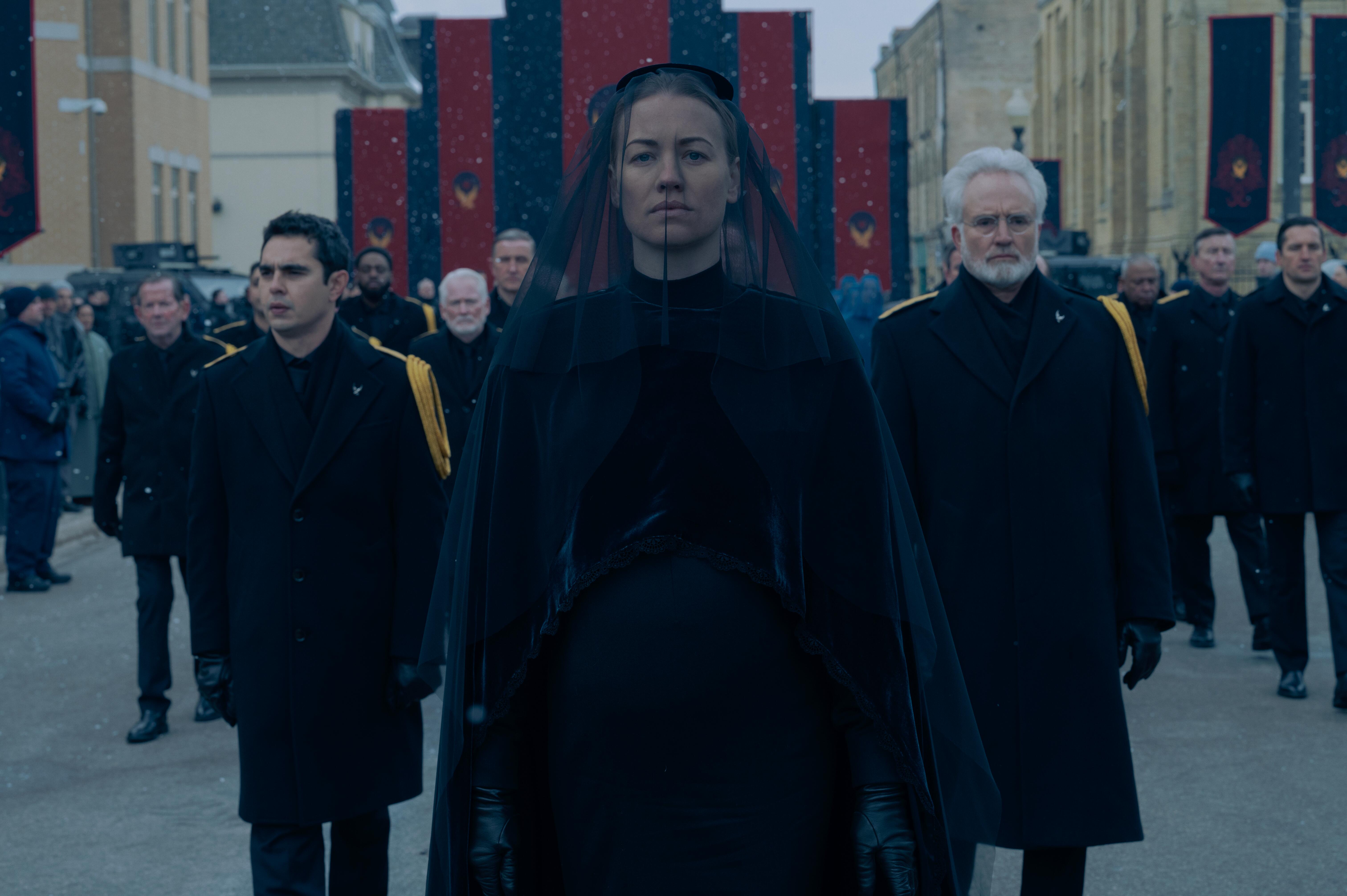 Nick Blaine, Serena Joy Waterford, and Joseph Lawrence walk in a funeral processional in 'The Handmaid's Tale'