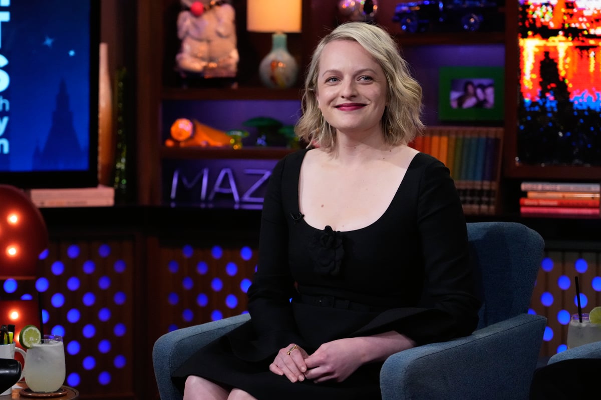 The Handmaid's Tale Season 5 star Elisabeth Moss smiles, wearing a black dress.