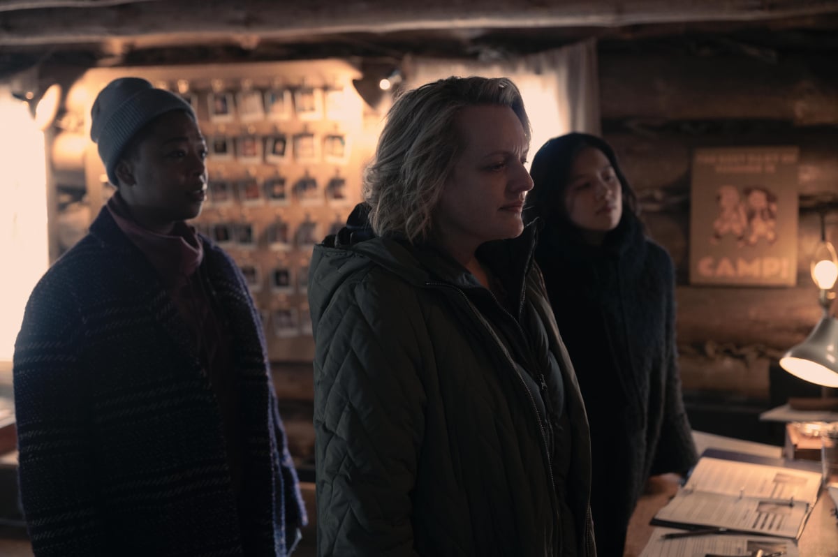 Christine Ko, Samira Wiley, and Elisabeth Moss in The Handmaid's Tale Season 5. June, Moira, and Lily look at a wall of photos in a Mayday outpost. 