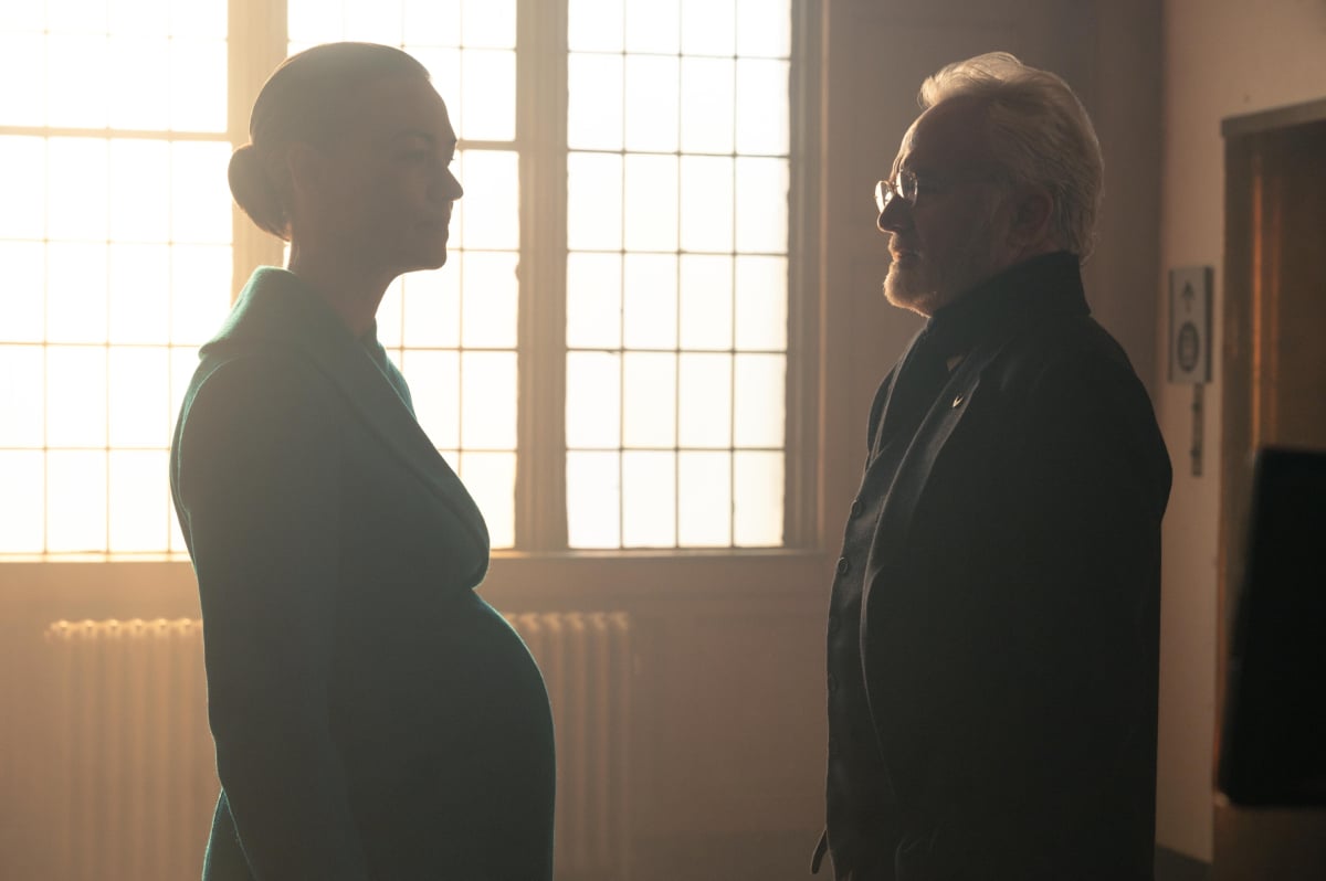 Serena Joy and Commander Lawrence in The Handmaid's Tale Season 5. Serena and Lawrence talk in a hallway in Gilead.