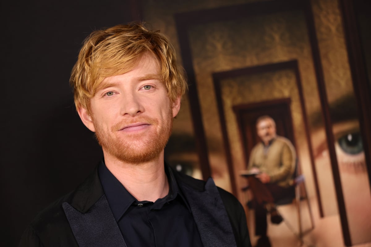 Domhnall Gleeson attends FX's The Patient Season 1 Premiere. Gleeson wears a black shirt and jacket and has red hair and a beard.