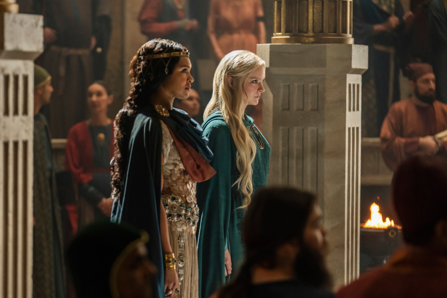 Cynthia Addai-Robinson and Morfydd Clark in 'The Rings of Power' for our article about episode 5's release date and time. The two are standing side by side before a crowd.