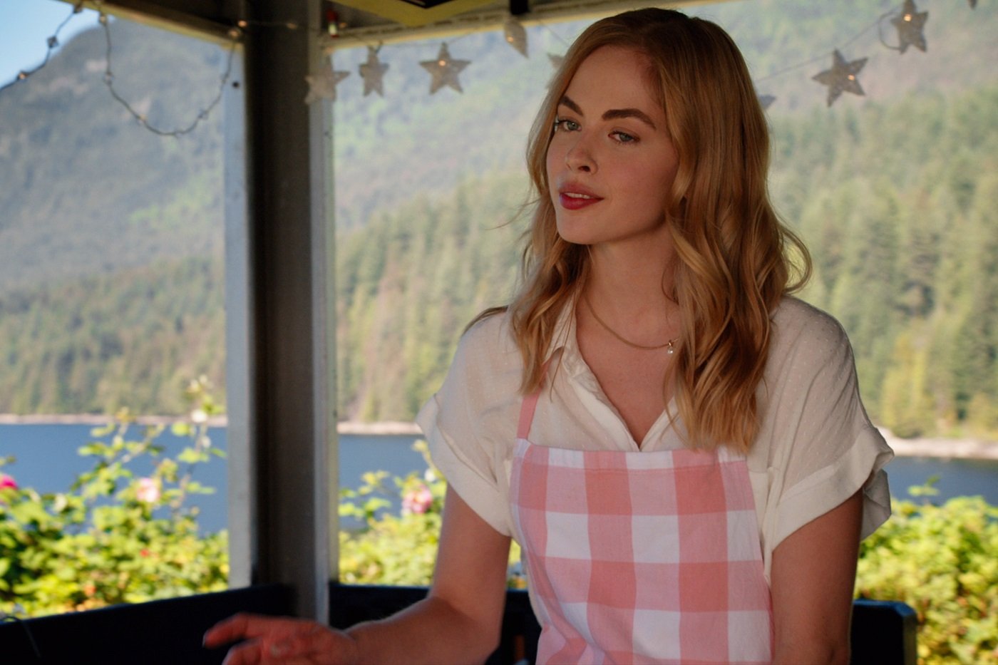 'Virgin River' actor Sarah Dugdale wearing a pink and white apron