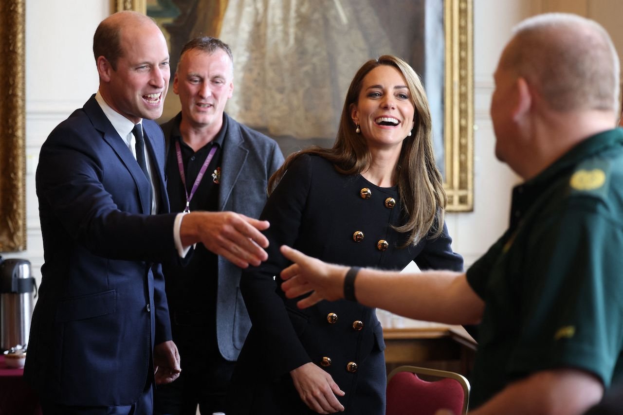 Prince William (L), Prince of Wales, and Kate Middleton, Princess of Wales, laugh as they visit the Guildhall in Windsor on September 22, 2022 to thank volunteers and staff who worked on the funeral of Britain's Queen Elizabeth II.