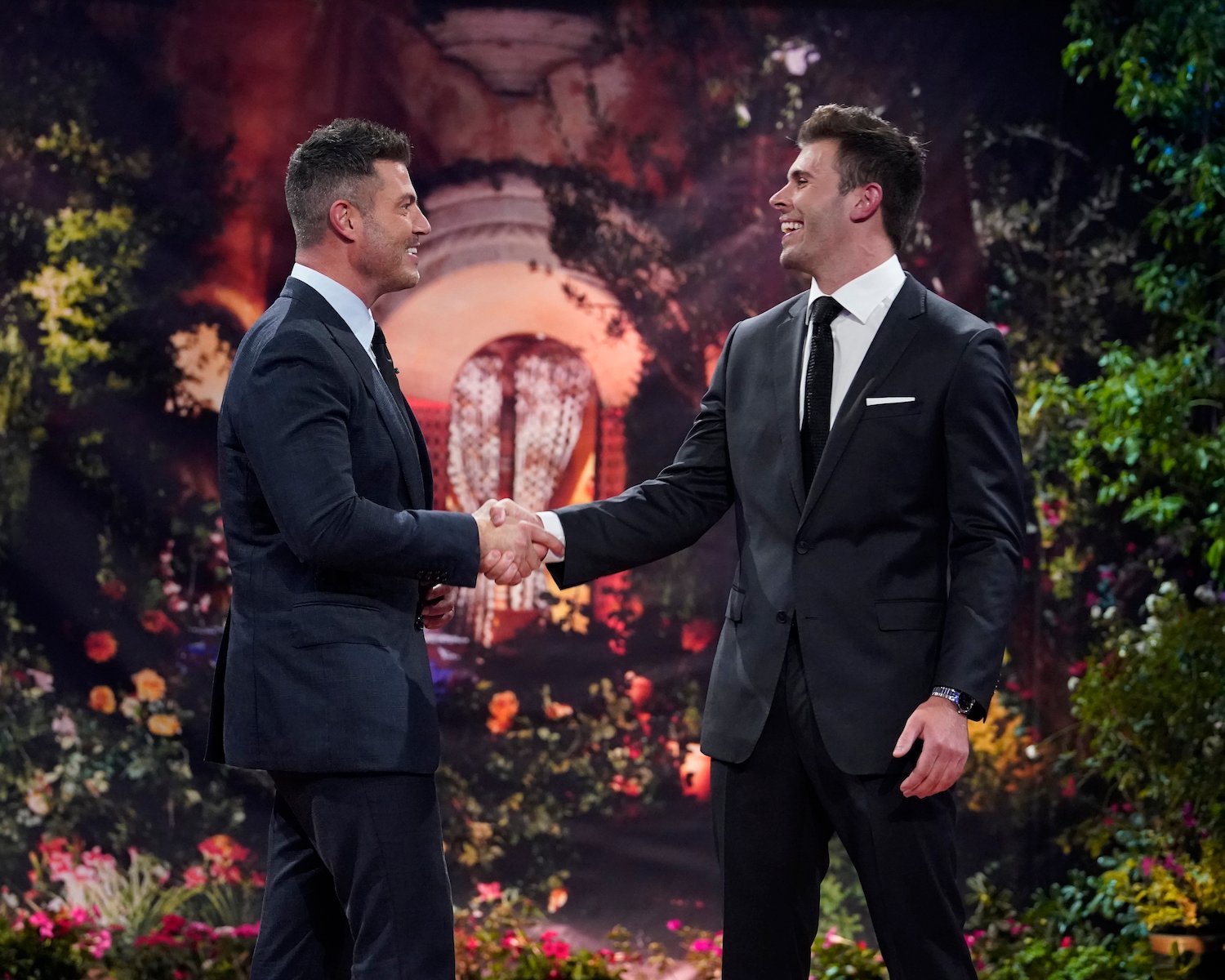 Jesse Palmer and Zach Shallcross shaking hands on stage. Zach is the lead for 'The Bachelor' Season 27