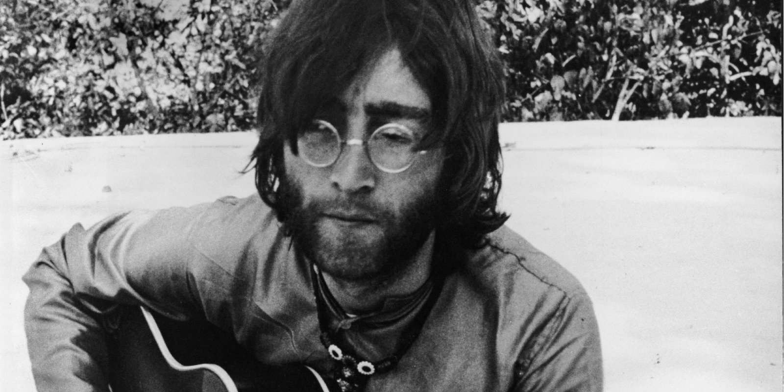 John Lennon jouant de la guitare à Rishikesh, en Inde, où il suivait un cours transcendantal avec le reste des membres des Beatles. 