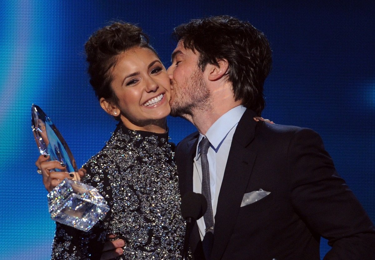 Ian somerhalder kisses Nina Dobrev on the cheek as she holds an awarrd for The Vampire Diaries