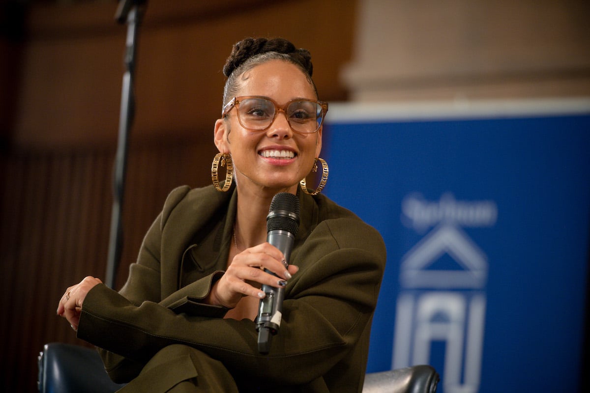 Alicia Keys smiling, holding a microphone