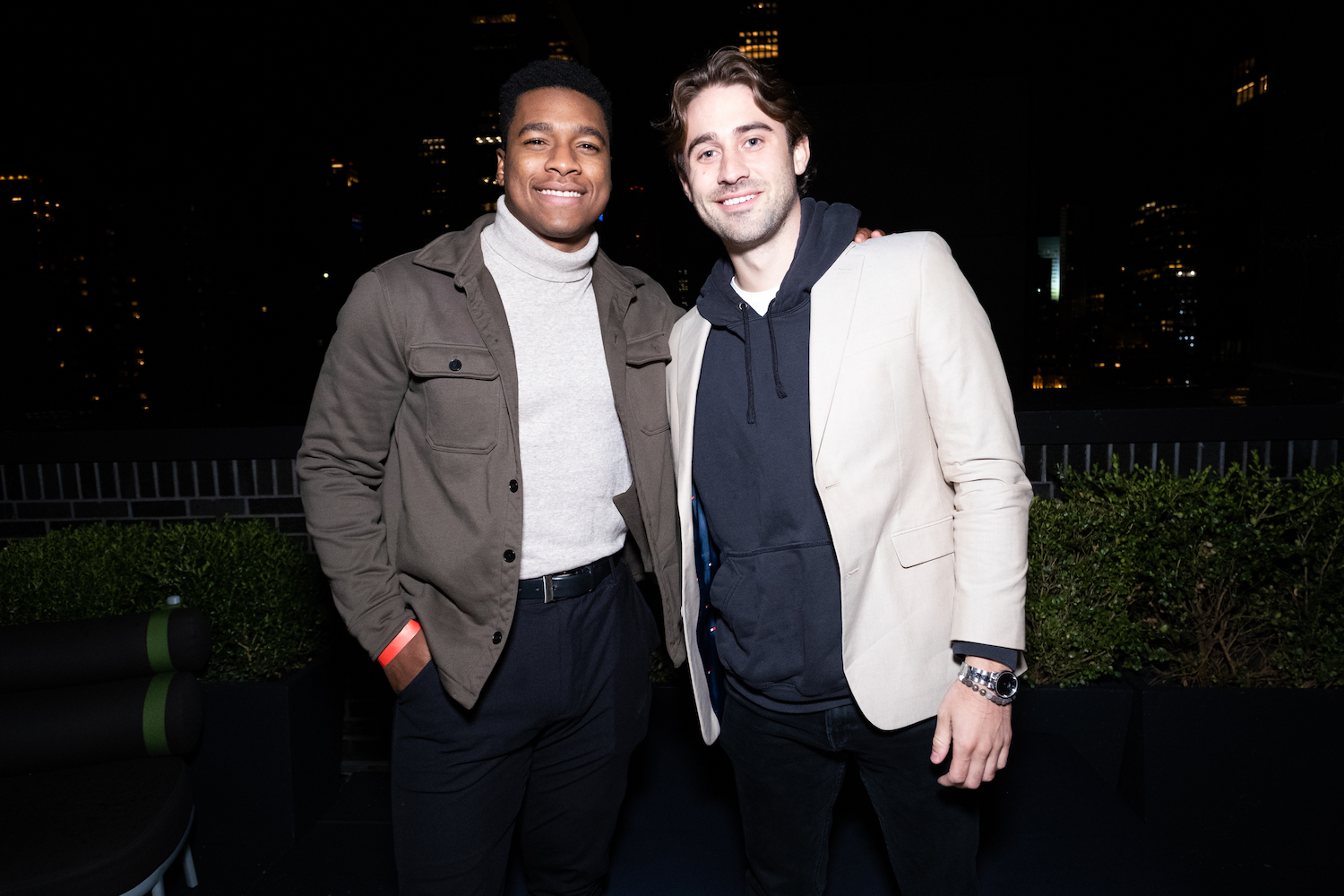 Andrew Spencer and Greg Grippo standing next to each other in the dark and smiling