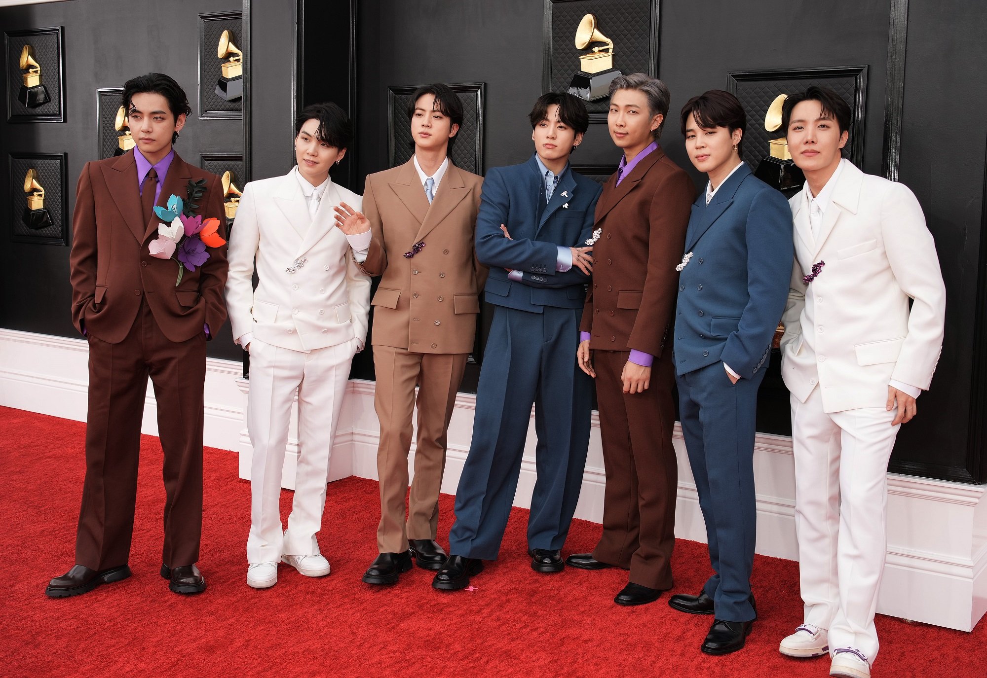 V, Suga, Jin, Jungkook, RM, Jimin, and J-Hope of BTS stand on the red carpet at the 2022 Grammy Awards