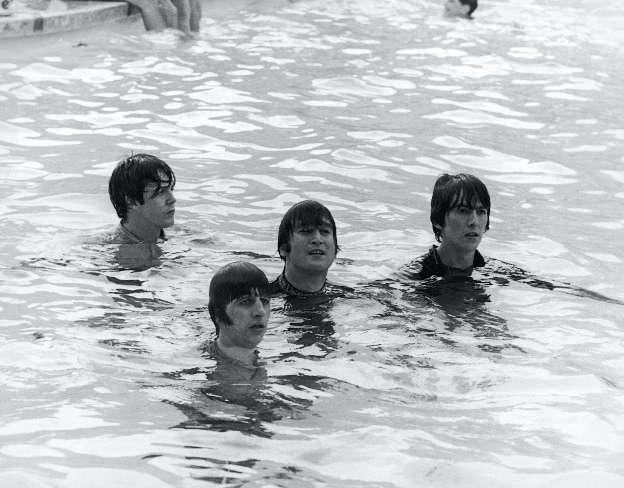 Paul McCartney (from left), Ringo Starr, John Lennon, and George Harrison of The Beatles swim in a pool while filming 'Help' in 1965. The Beatles celebrated hitting No. 1 by asking a colleague to go for a swim.