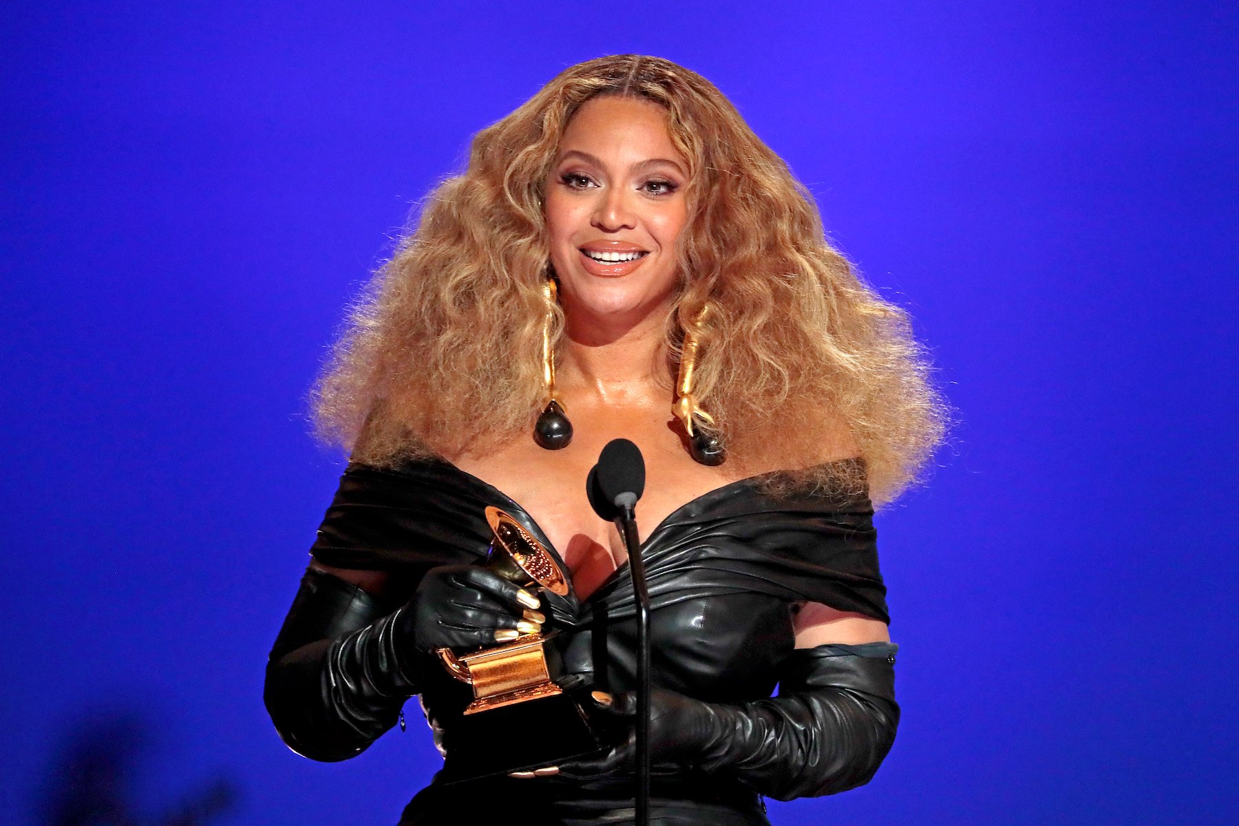 Beyoncé, who sampled a song by Right Said Fred, wearing a black dress against a blue backdrop