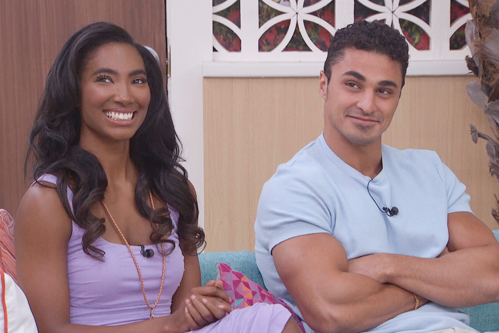 Taylor Hale and Joseph Abdin, who starred in 'Big Brother 24' on CBS, sit together on a couch. Taylor wears a light purple dress. Joseph wears a light blue shirt.