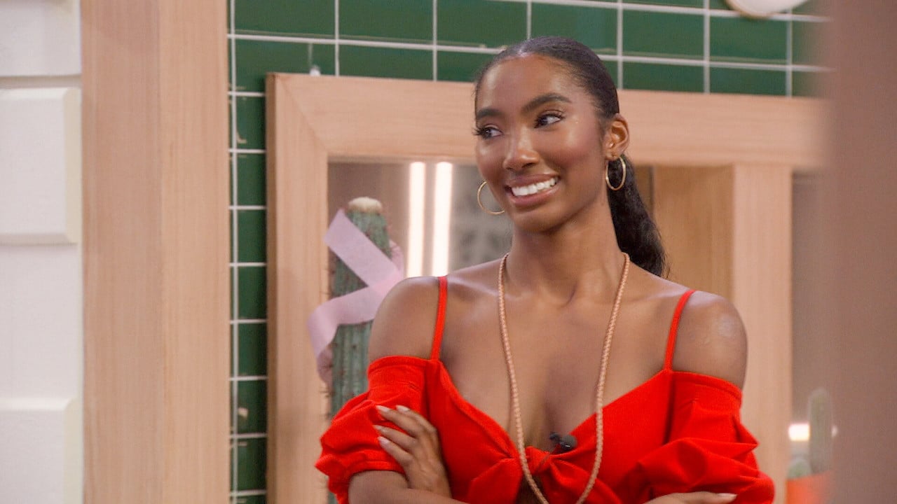 Taylor Hale stands smiling in a red dress on 'Big Brother 24'.