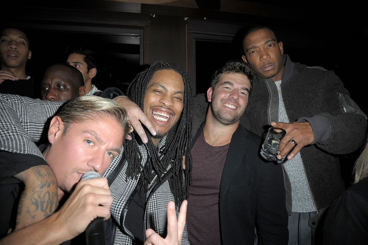 Billy McFarland smiles with Ja Rule, Matthew Assante, and Waka Flocka, while drinking at a bar in 2016