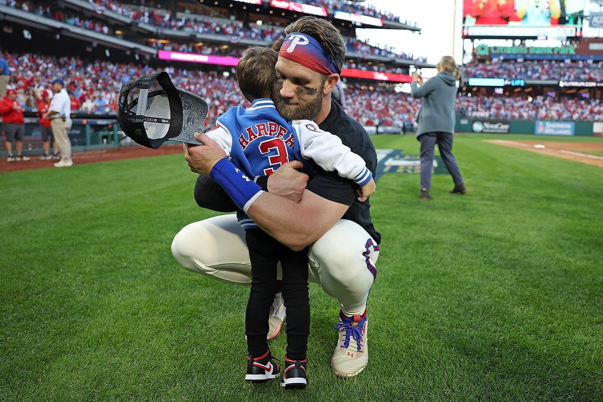 Bryce Harper hugs his son, Krew Harper , after defeating the Atlanta Braves in the playoffs