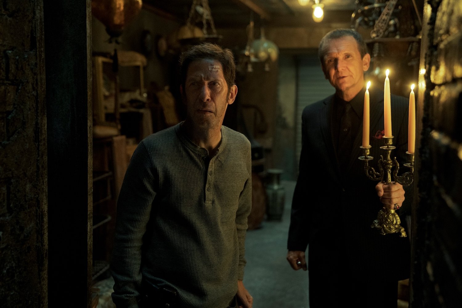 'Cabinet of Curiosities' episode 'Lot 36' stars Tim Blake Nelson and Sebastian Roche, seen here peering into a secret room in a production still.