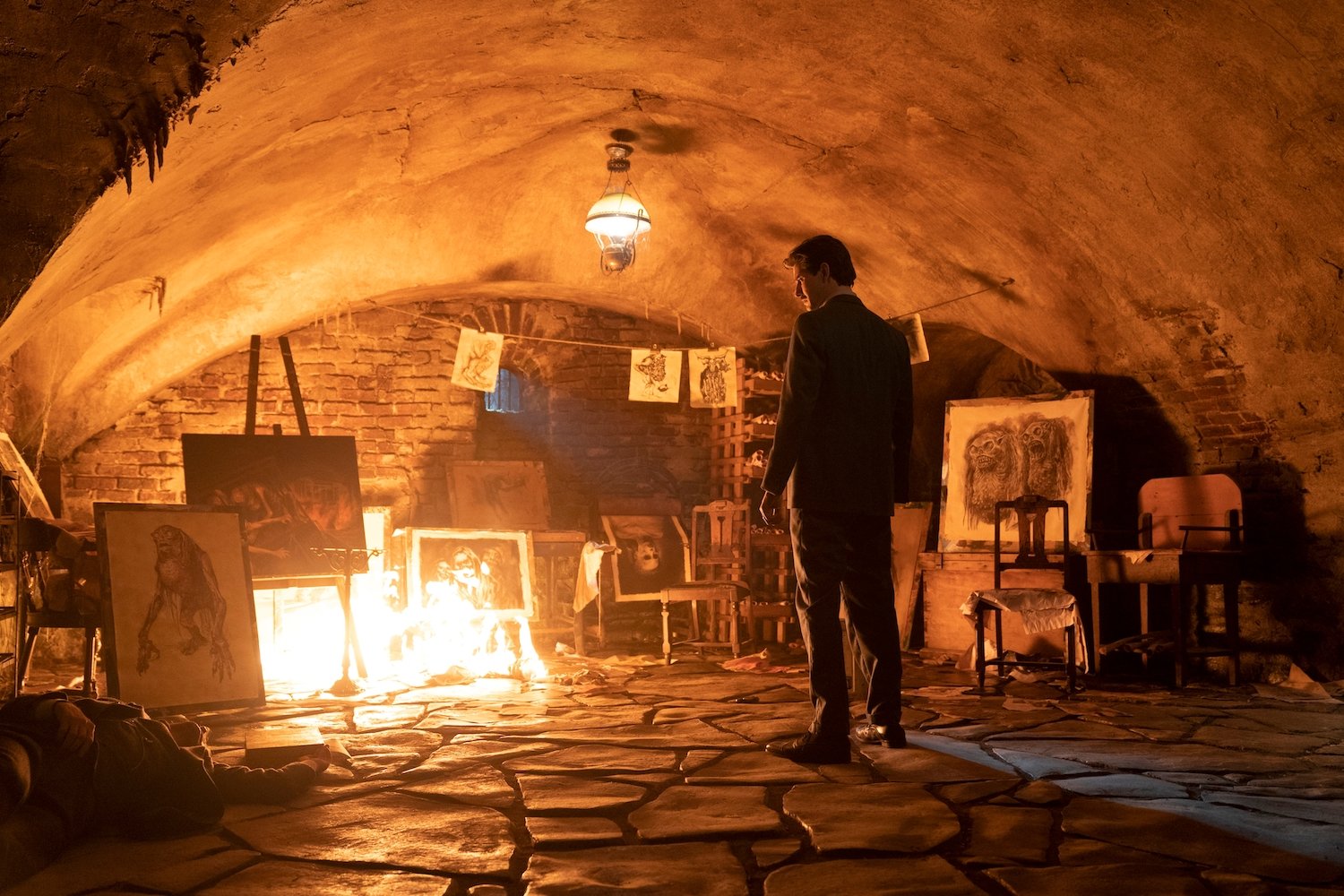 'Cabinet of Curiosities' episode 'Pickman's Model' star Ben Barnes as Thurber looking at the macabre sketches by Pickman.