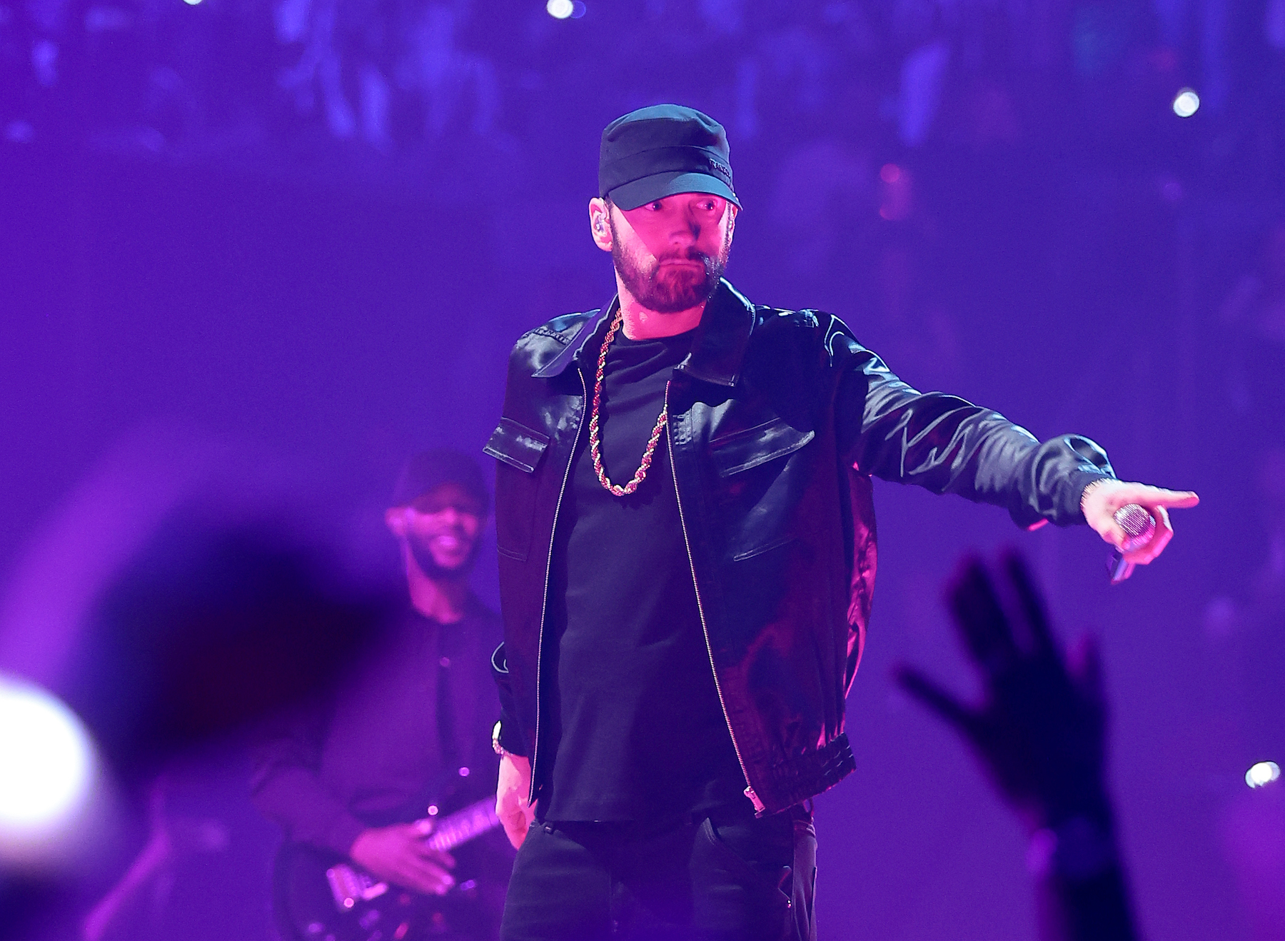 Eminem, who has had many hit songs over the years, wearing a black leather jacket and performing.