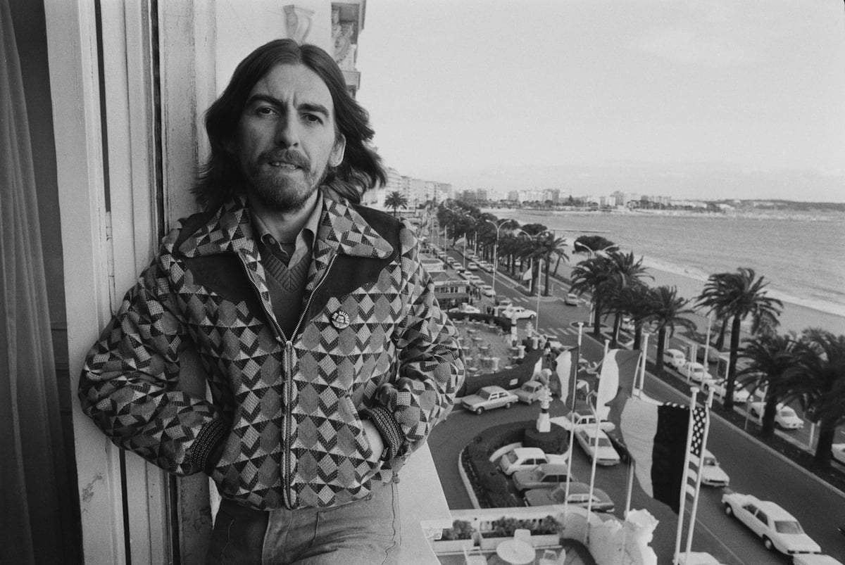 George Harrison sitting on a window ledge, in black and white