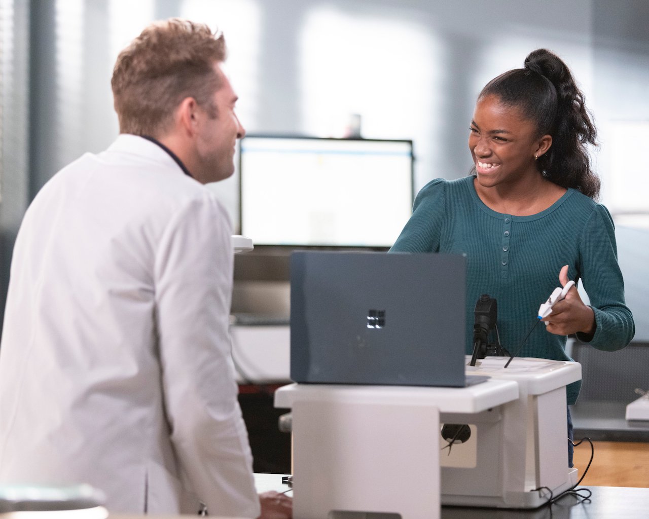 Scott Speedman as Nick Marsh looks at Aniela Gumbs as Zola Gey-Shephard as she's holding tools in front of a computer on 'Grey's Anatomy'.