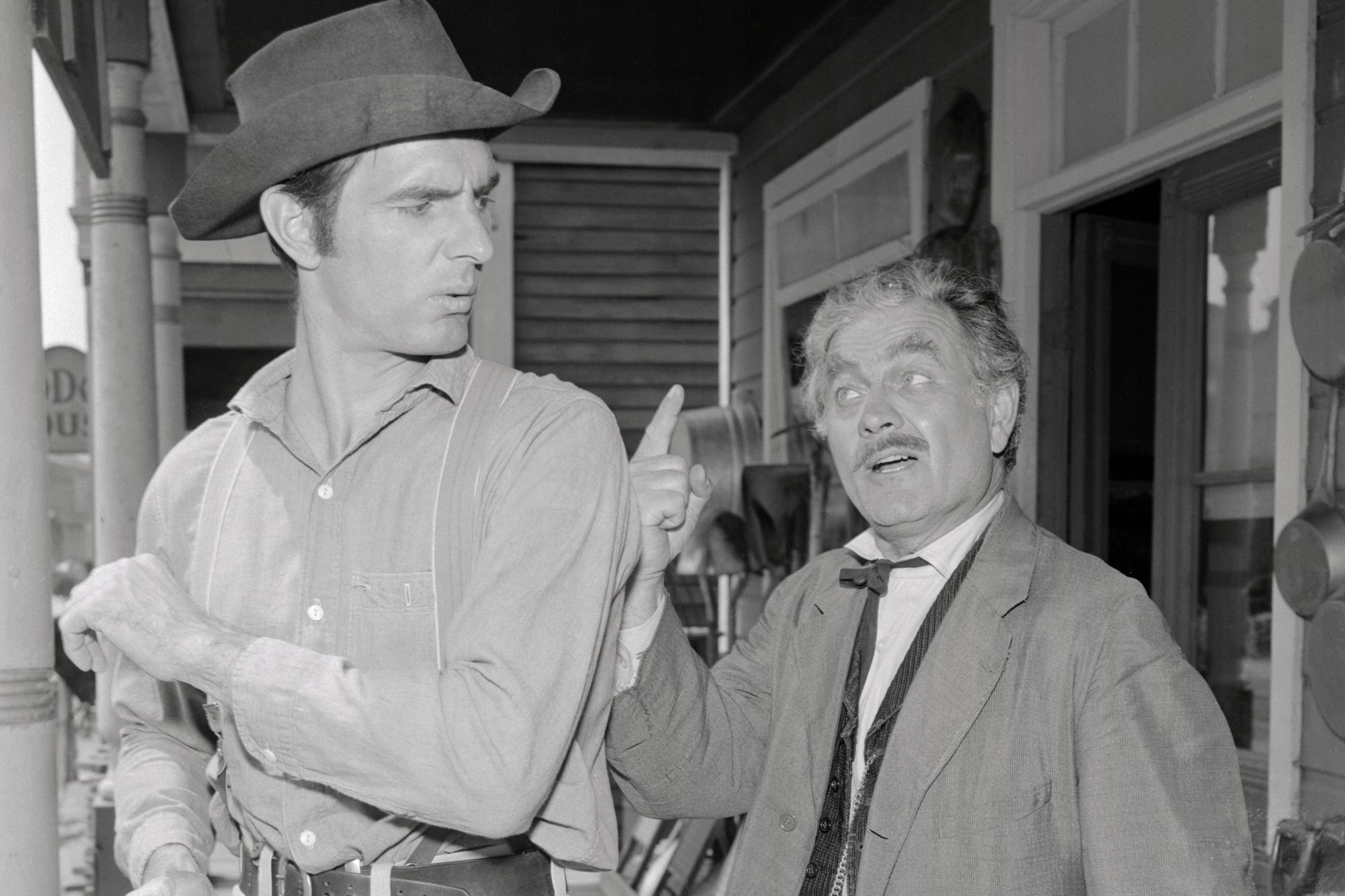 'Gunsmoke' Dennis Weaver as Chester Goode and Milburn Stone as Doc Adams. Stone is holding up his finger at Weaver, who is holding his arm away from him.