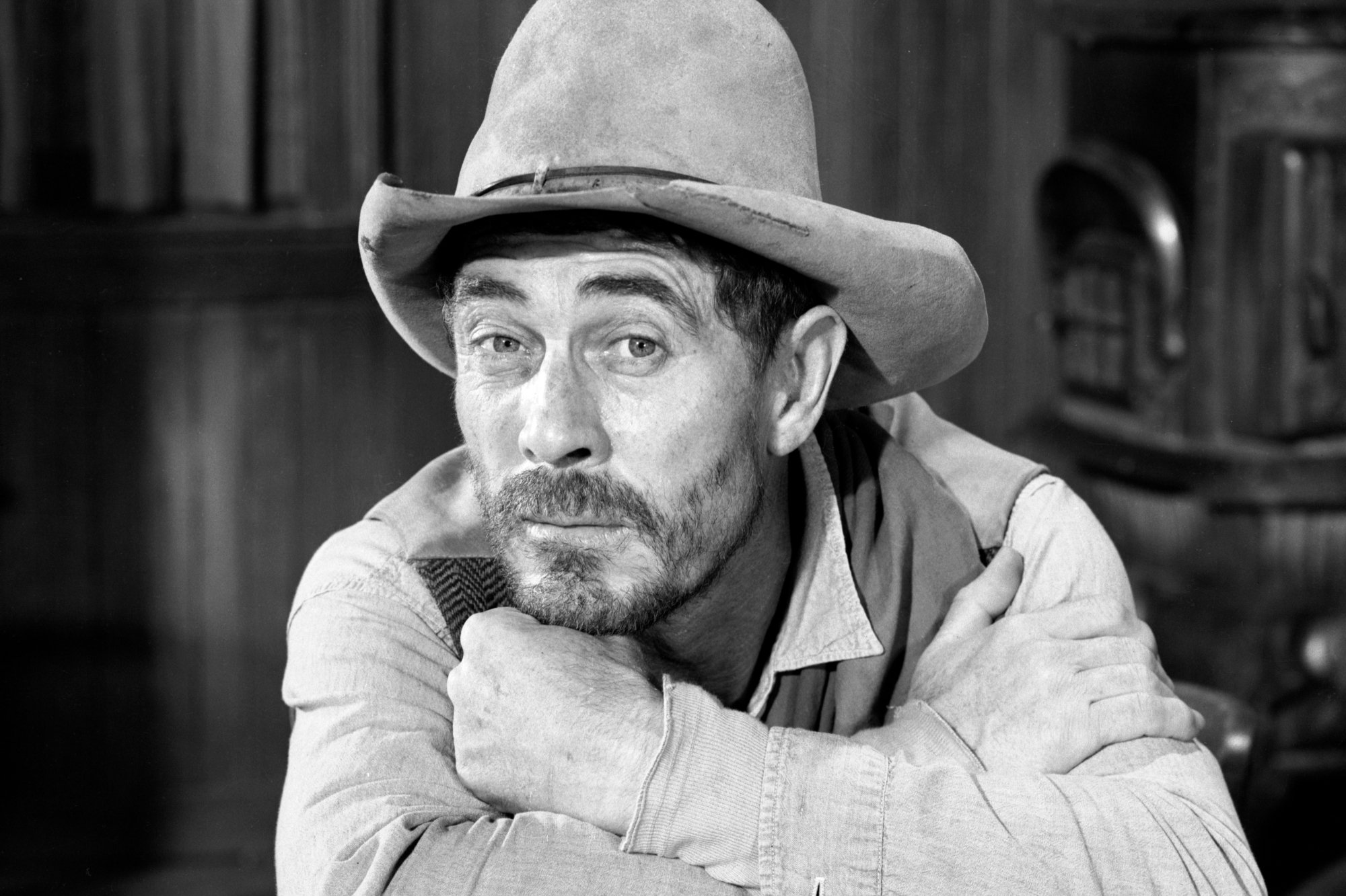 'Gunsmoke' Ken Curtis as Festus Haggen in Western costume. Resting his chin on his arms folded on a table.