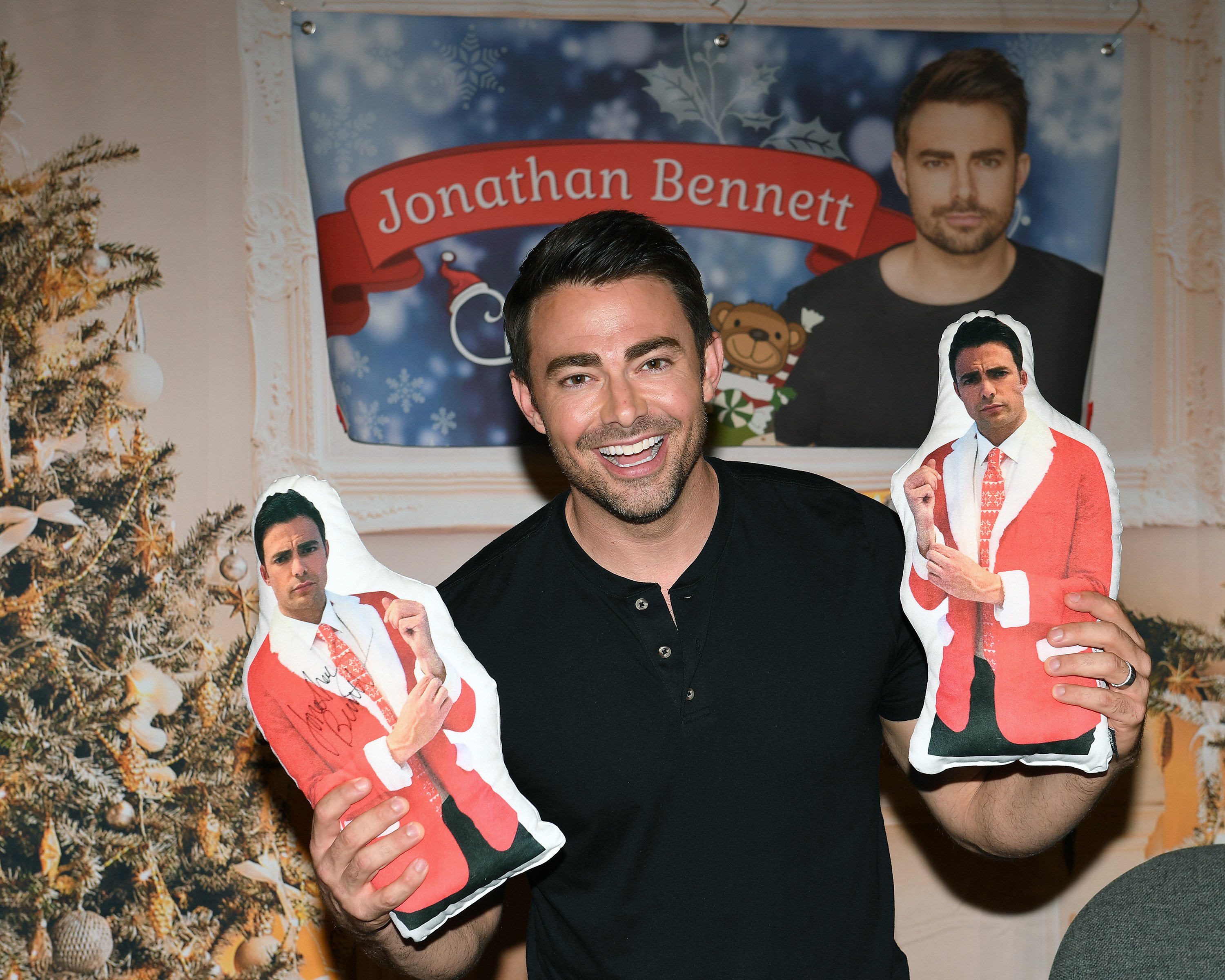 Hallmark actor Jonathan Bennett posing with two pillows of himself