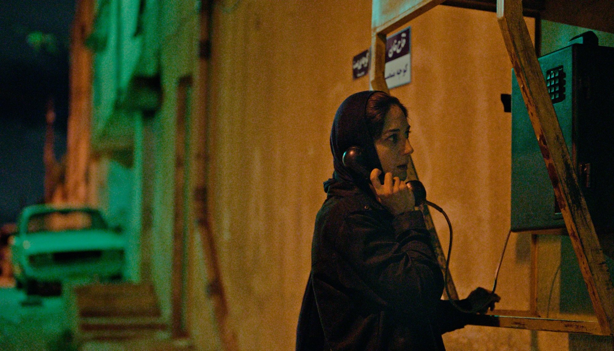 'Holy Spider' Far Amir-Ebrahimi as Rahimi looking frightened, talking on a public phone at night.