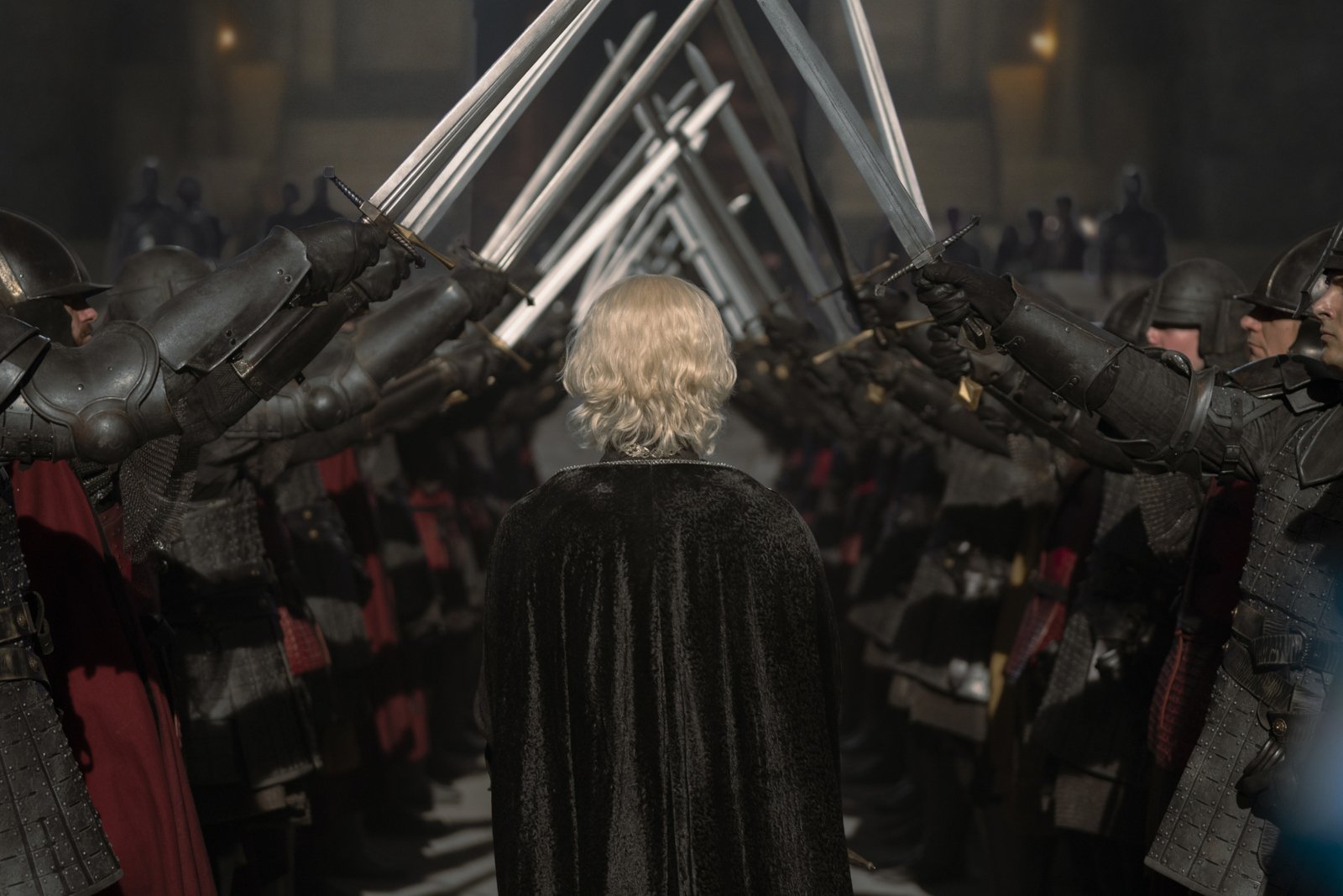 Tom Glynn-Carney as Aegon in 'House of the Dragon' for our article about episode 10/the finale and its release date. He's walking through a crowd of people with their swords raised.