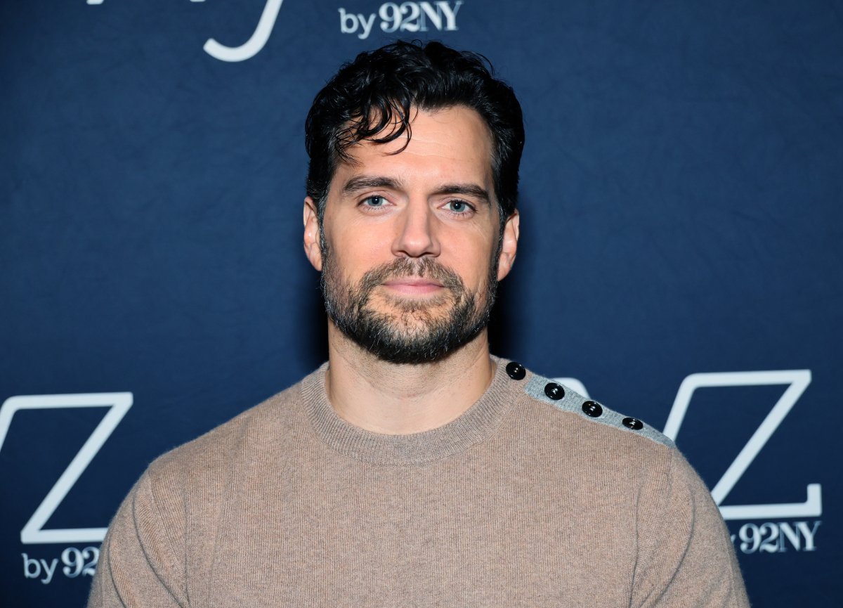 Henry Cavill addresses rumors about him joining House of the Dragon. Cavill wears a biege sweater.