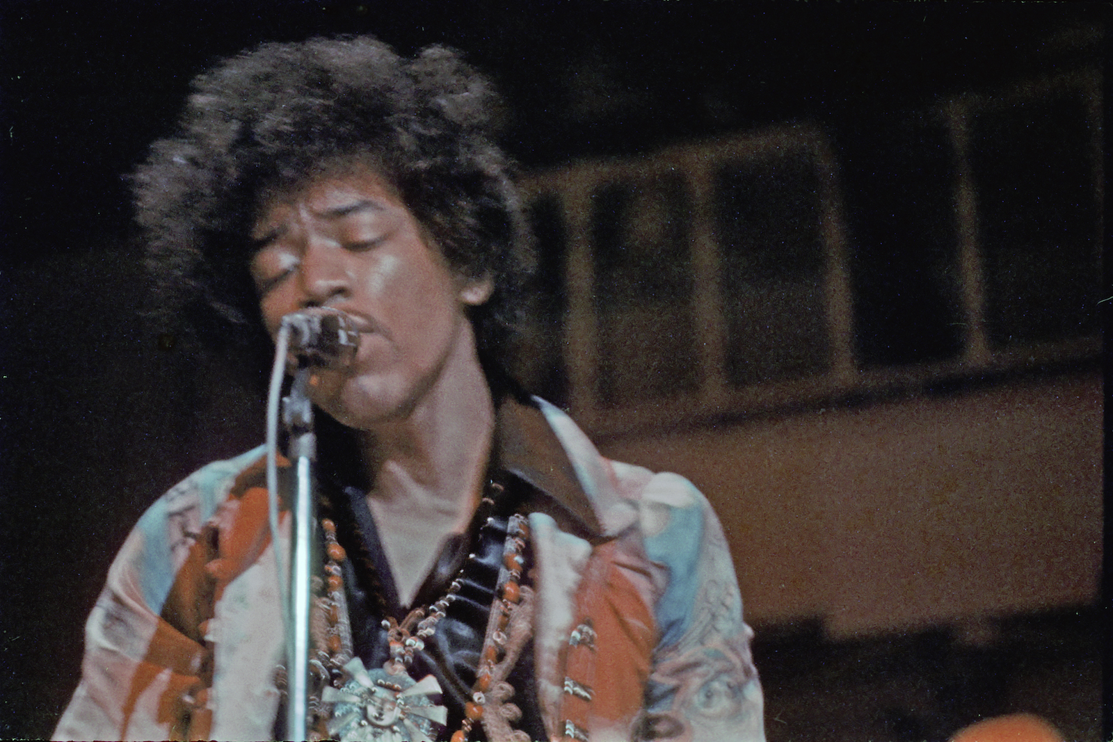 Jimi Hendrix, who had a rough childhood, singing into a microphone