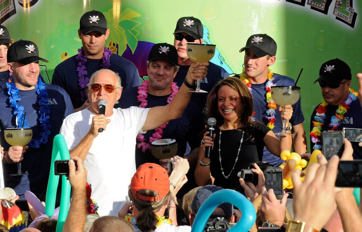 Recording artist Jimmy Buffett and Margaritaville Director of Marketing Tamara Baldanza stand with members of the Wounded Warrior Amputee Softball Team as they toast the crowd during the grand opening celebration for the Margaritaville Casino at Flamingo Las Vegas in 2011