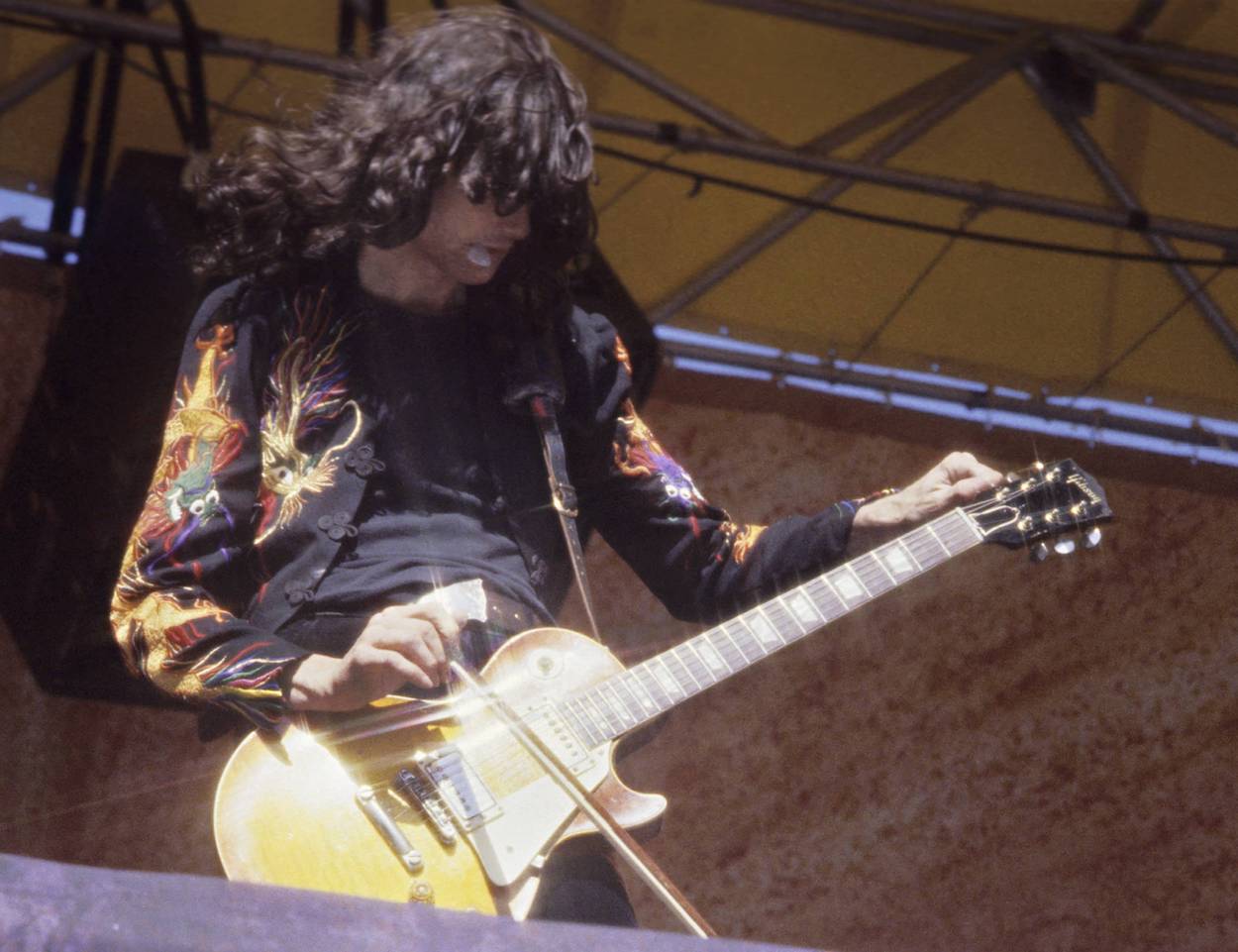 Jimmy Page plays during a 1977 Led Zeppelin concert in Oakland, California. Page tuned his guitar in a strange way when he first started playing.