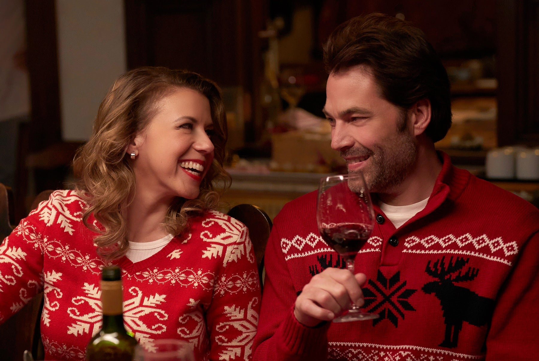Jodie Sweetin and Tim Rozon wearing Christmas sweaters in the Lifetime movie 'Merry Swissmas