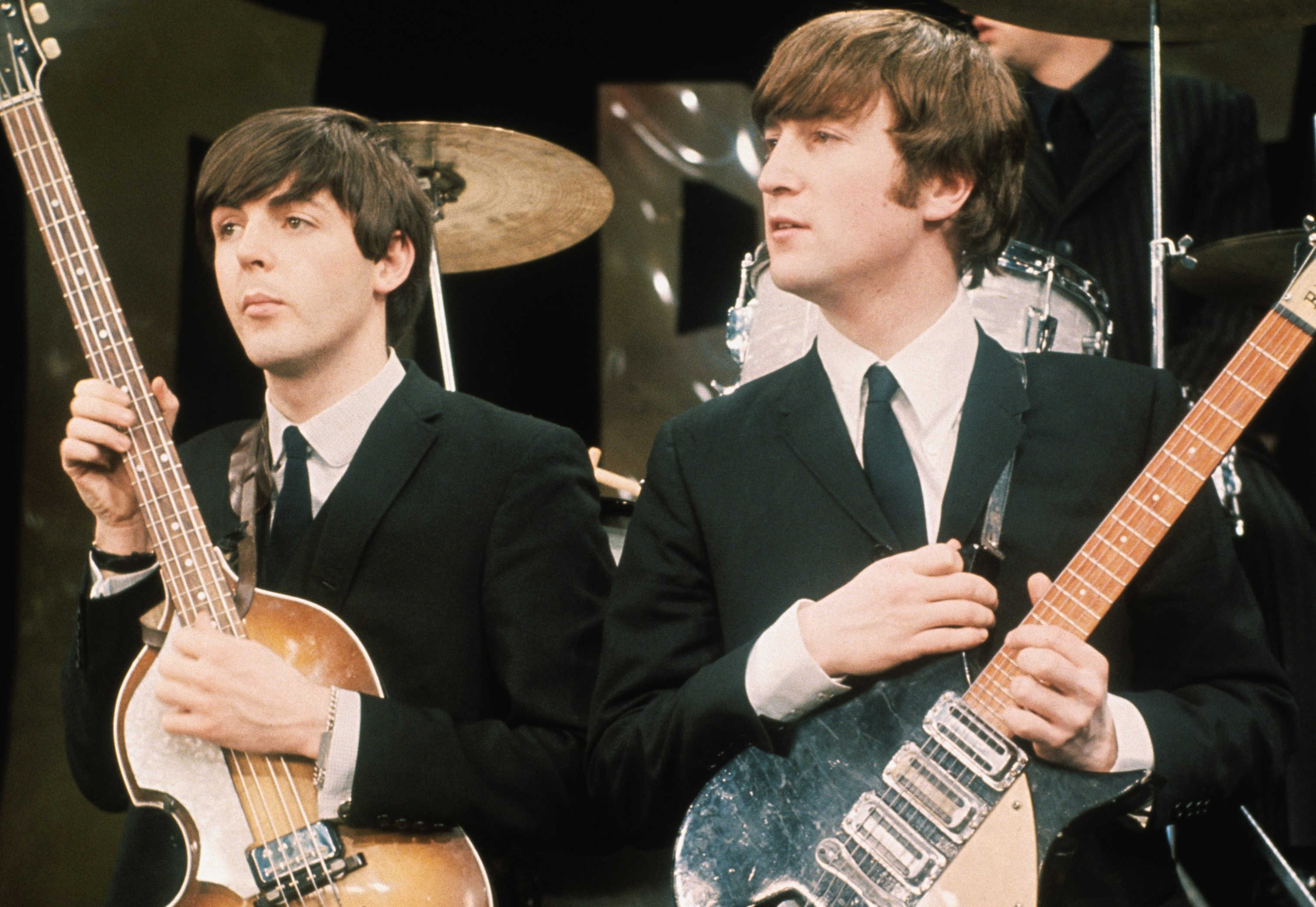 Paul McCartney and John Lennon holding guitars during The Beatles' "I Saw Her Standing There" era