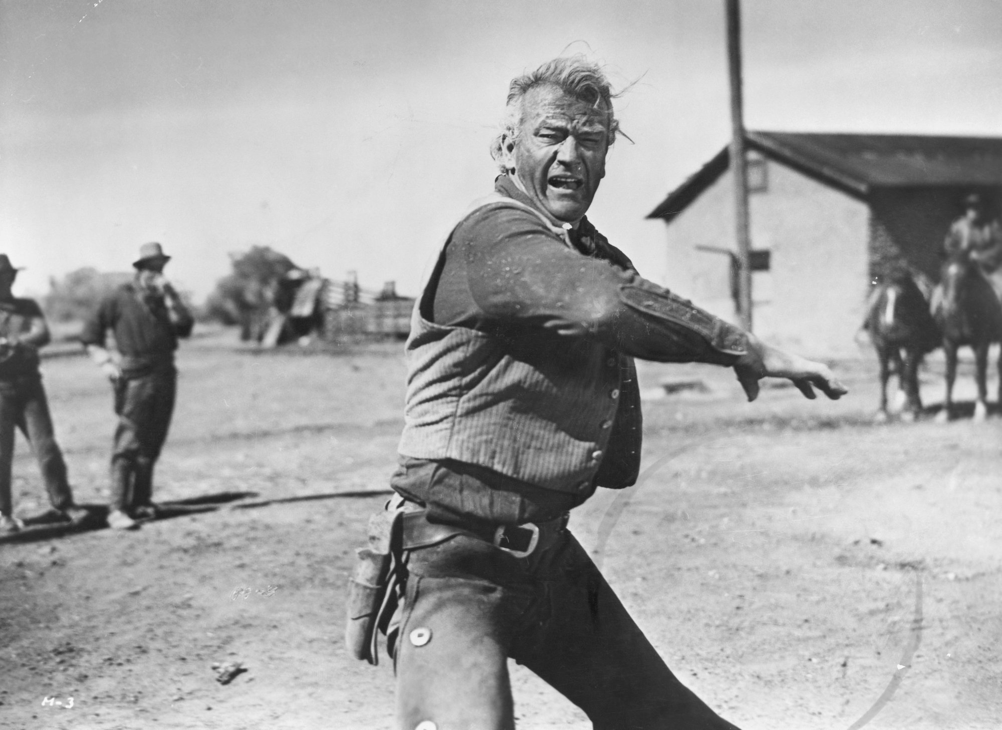 'Red River' actor John Wayne, who calmed a riot. He's wearing Western clothes and shouting, while waving his arm.