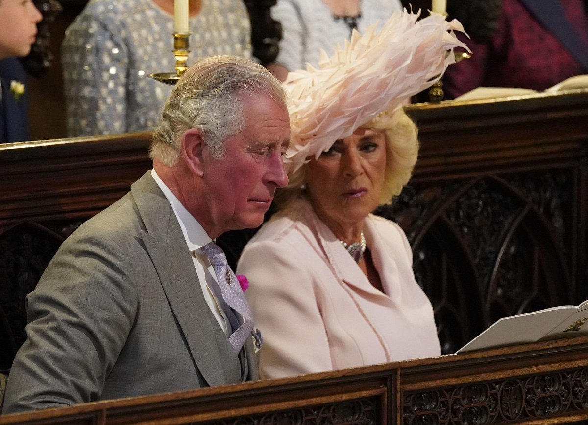 King Charles III and Camilla Parker Bowles, who became upset with the Sussexes over their treatment of Charles, sitting in the pew of St. George's Chapel ahead of Prince Harry and Meghan Markle's wedding