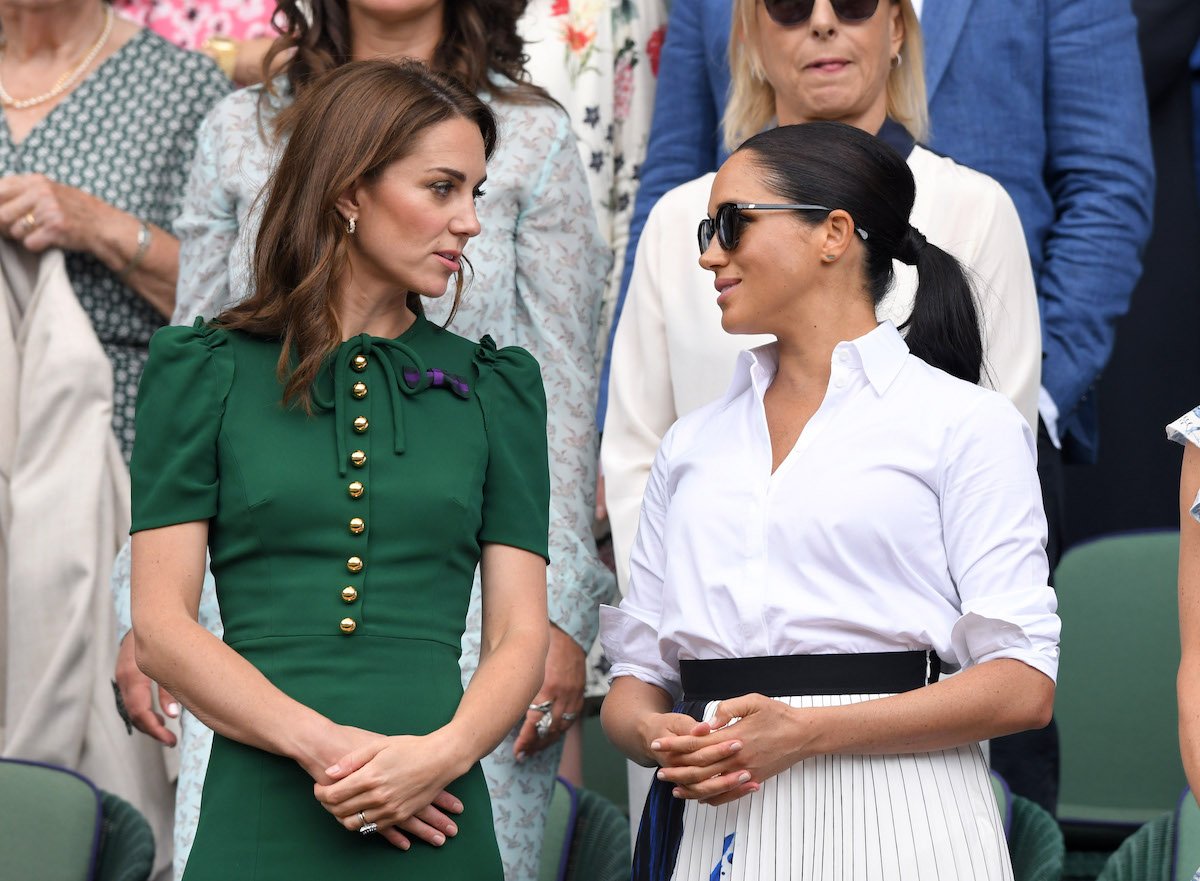 Kate Middleton and Meghan Markle, who was told to dress more like Kate Middleton according to Katie Nicholl's 'The New Royals' book, stand next to each other at Wimbledon in 2019