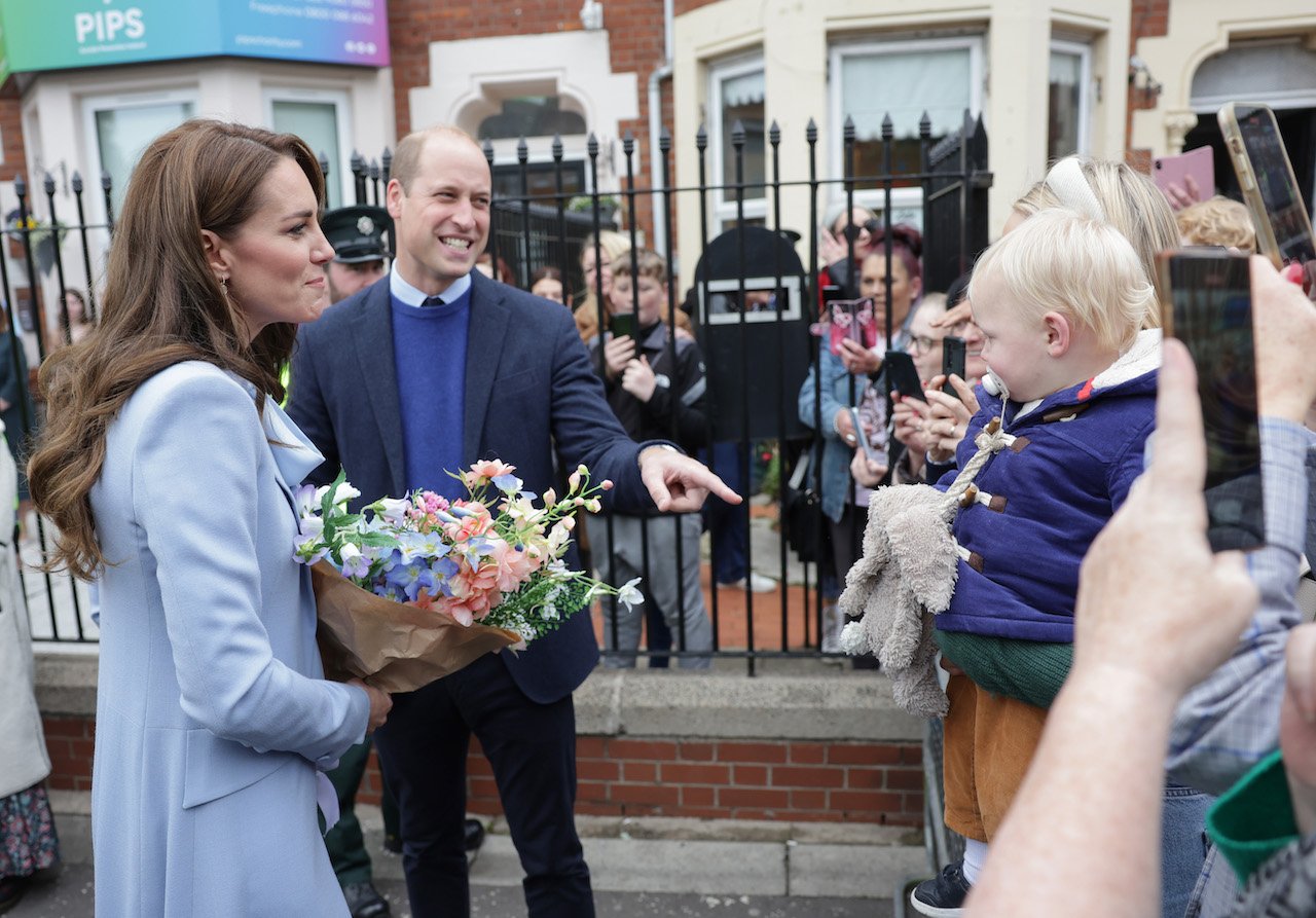 Kate Middleton, Princess of Wales, and Prince William, Prince of Wales smile as they speak with well-wishers and a baby after their visit to the PIPS (Public Initiative for Prevention of Suicide and Self Harm) charity on October 06, 2022, in Belfast, Northern Ireland.