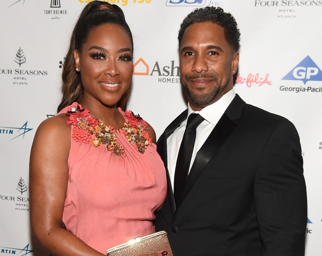 Kenya Moore poses for photo alongside Marc Daly; Moore wishes she would have signed a prenup before they wed