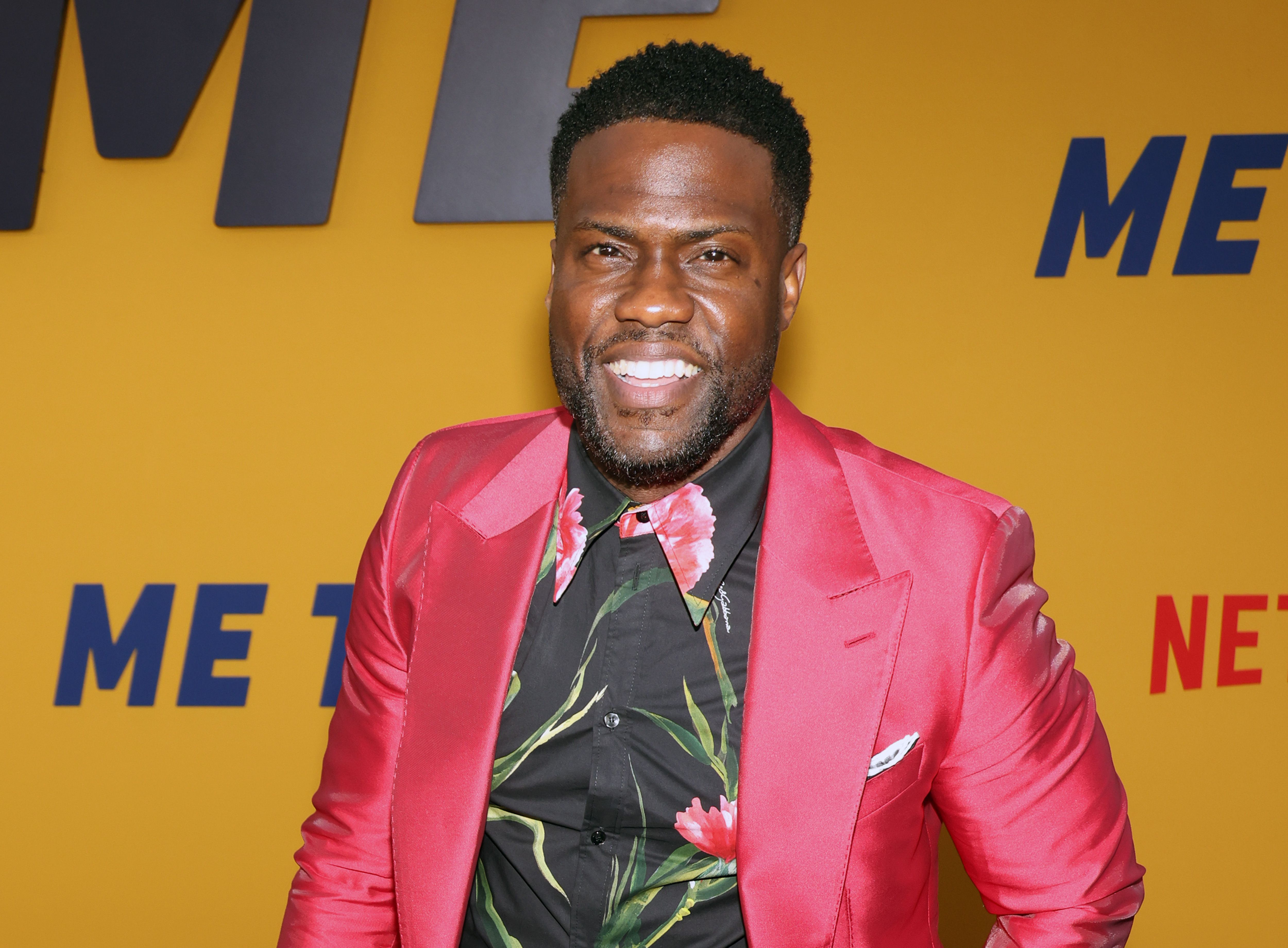 Kevin Hart. who bought two mansions right next door to each other, smiling on the red carpet of the Los Angeles premiere of Netflix's 'Me Time'