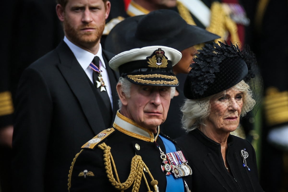 King Charles, who a royal expert says wouldn't have 'purposefully' waited to tell Prince Harry about Queen Elizabeth's death until after public announcement, looks on as he stands next to Camilla Parker Bowles, Prince Harry, and Meghan Markle at Queen Elizabeth's funeral on Sept. 19, 2022